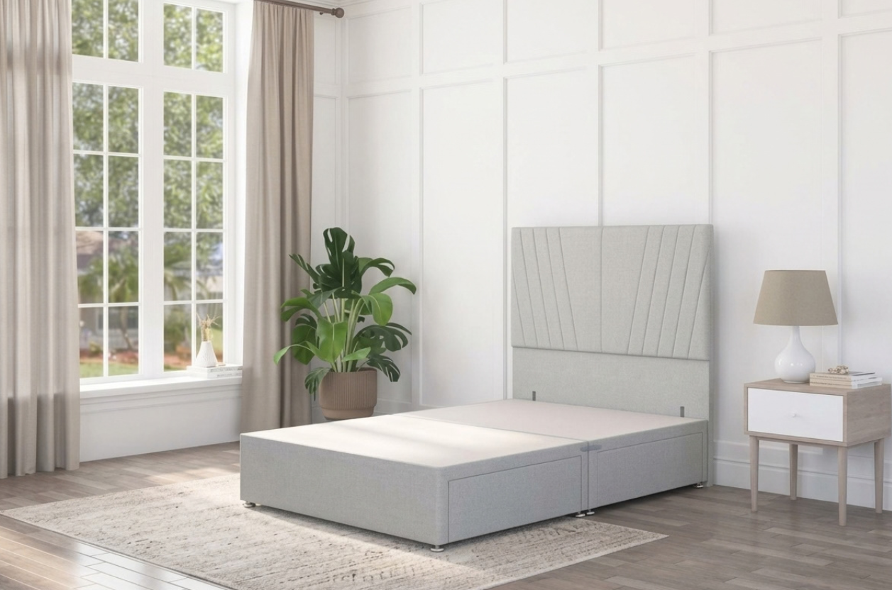 A grey divan bed made with plush velvet and completed with panelled headboard, in a modern interior with storage drawers. 
